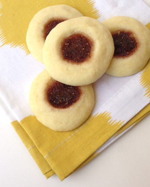 almond fig thumbprint cookies on a yellow and white napkin