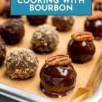 A baking tray with bourbon-infused chocolate truffles, some topped with pecans and others coated in crumbs. A sign above reads, "How to Cook with Bourbon: Tips for Cooking with Bourbon.