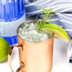 a gin mule with a lime and rosemary garnish