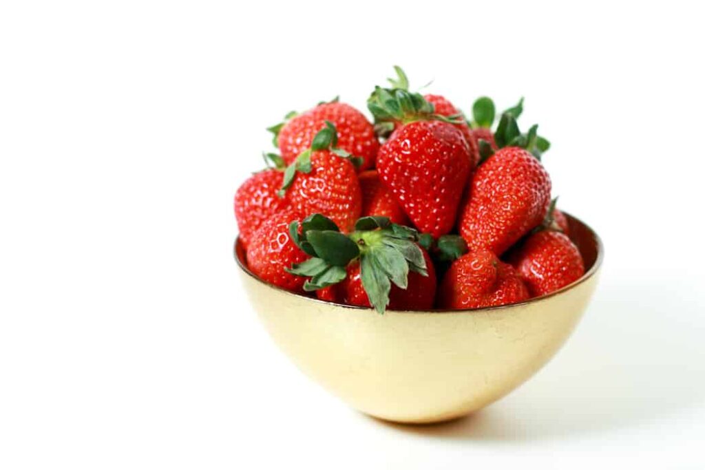 Strawberry mimosa in a gold bowl on a white background.