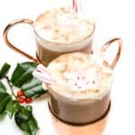 A boozy peppermint hot chocolate topped with whipped cream and candy canes.