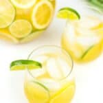 two glasses of margarita sangria next to a pitcher of the same