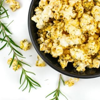 Pizza popcorn in a bowl with fresh rosemary