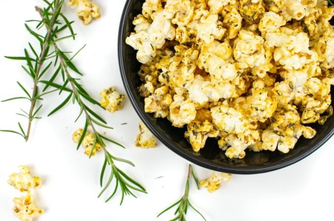 Pizza popcorn in a bowl with fresh rosemary