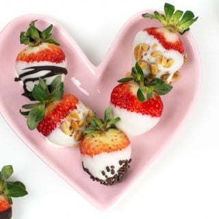 chocolate covered strawberries on a pink plate shaped like a heart