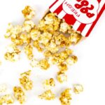 top view of caramel popcorn recipe spilling out of a popcorn container