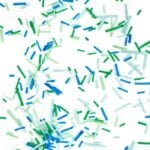 green and blue homemade sprinkles scattered all over a white surface