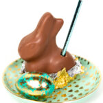 a chocolate easter bunny cocktail sitting on a green and gold plate with an easter egg.