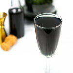 a black french 75 on a white background with black vodka