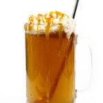 a glass of boozy Harry Potter butterbeer with a long copper spoon resting in the glass