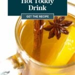 A clear glass mug filled with bourbon hot toddy, garnished with a cinnamon stick, star anise, and a lemon slice.