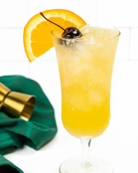 hurricane cocktail with an orange wedge and cherry