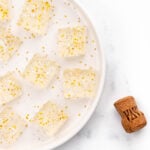 a champagne cork next to a tray of champagne jello shots