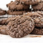 a Double Chocolate Chip Cookie leaning against a stack of cookies