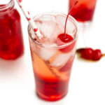 a Shirley Temple with a straw and a cherry on top