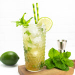 a virgin mojito on a wooden board with mint and a lime