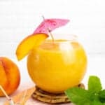 a frozen peach daiquiri on a wooden coaster