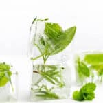 a stack of herb ice cubes with fresh herbs