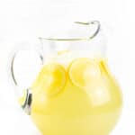 a pitcher of homemade lemonade on a white background