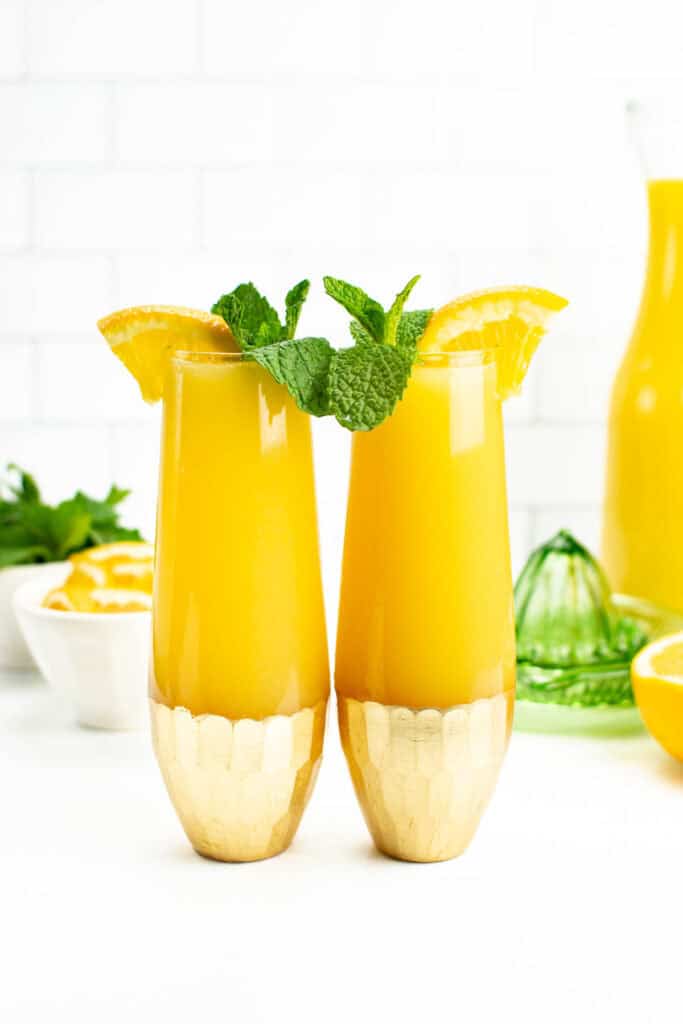two non-alcoholic mimosas with a citrus juicer