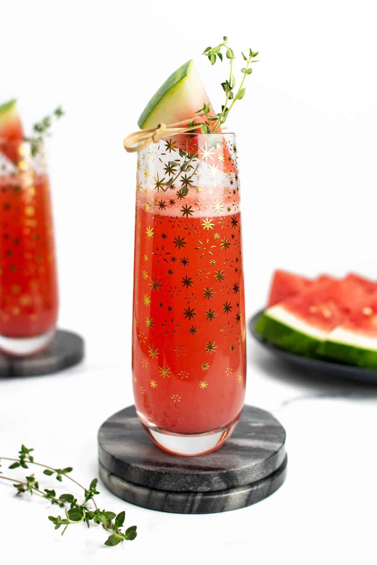 a watermelon mimosa in a stemless flute covered in stars