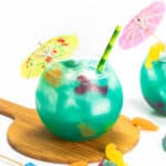 a yellow parasol on top of a blue fish bowl drink