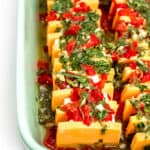 A light green baking dish contains cheese slices, pimentos and marinade