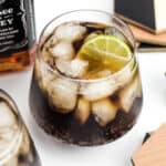 a bottle of Jack Daniel's rests next to two cola cocktails