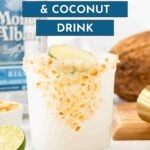 A glass of coconut margarita garnished with toasted coconut flakes and a lime wedge, with a bottle of tequila, lime, and coconut in the background.