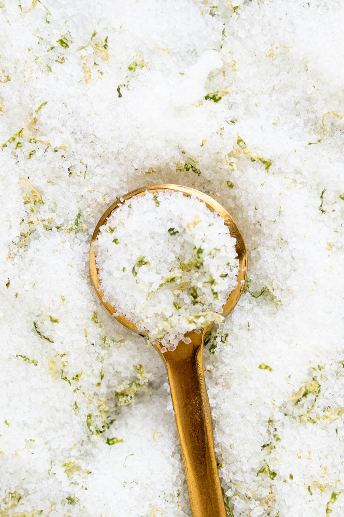 A gold spoon sits holding salt for rimming margaritas.