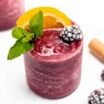 A Frozen Sangria with orange slices and mint leaves next to a wine cork.
