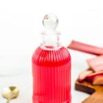 A glass bottle with a red liquid in it.