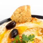 A bowl of Whipped Feta Dip with olives and pita bread.