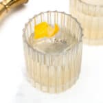 Two glasses of White Negroni on a marble table.