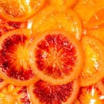 Sliced blood oranges on a white plate.