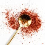 A gold spoon with chile lime seasoning on it.