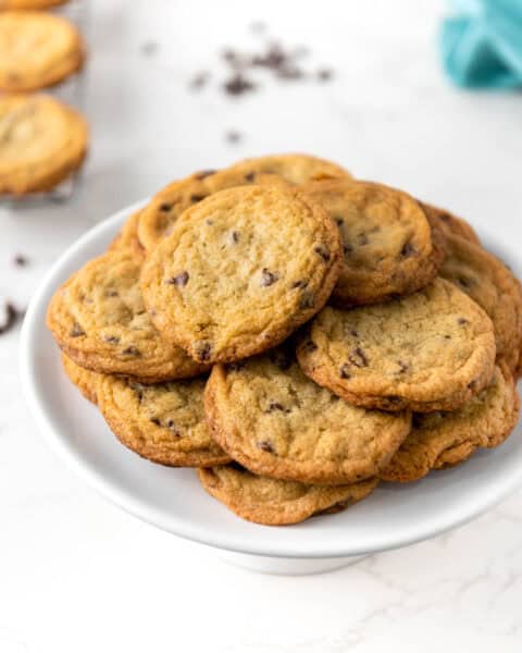 A stack of chocolate chip cookies on a white plate.