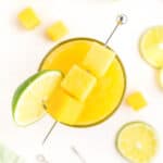 Mango Agua Fresca with lime wedges.
