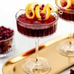 Two glasses of pomegranate martini cocktail on a tray.
