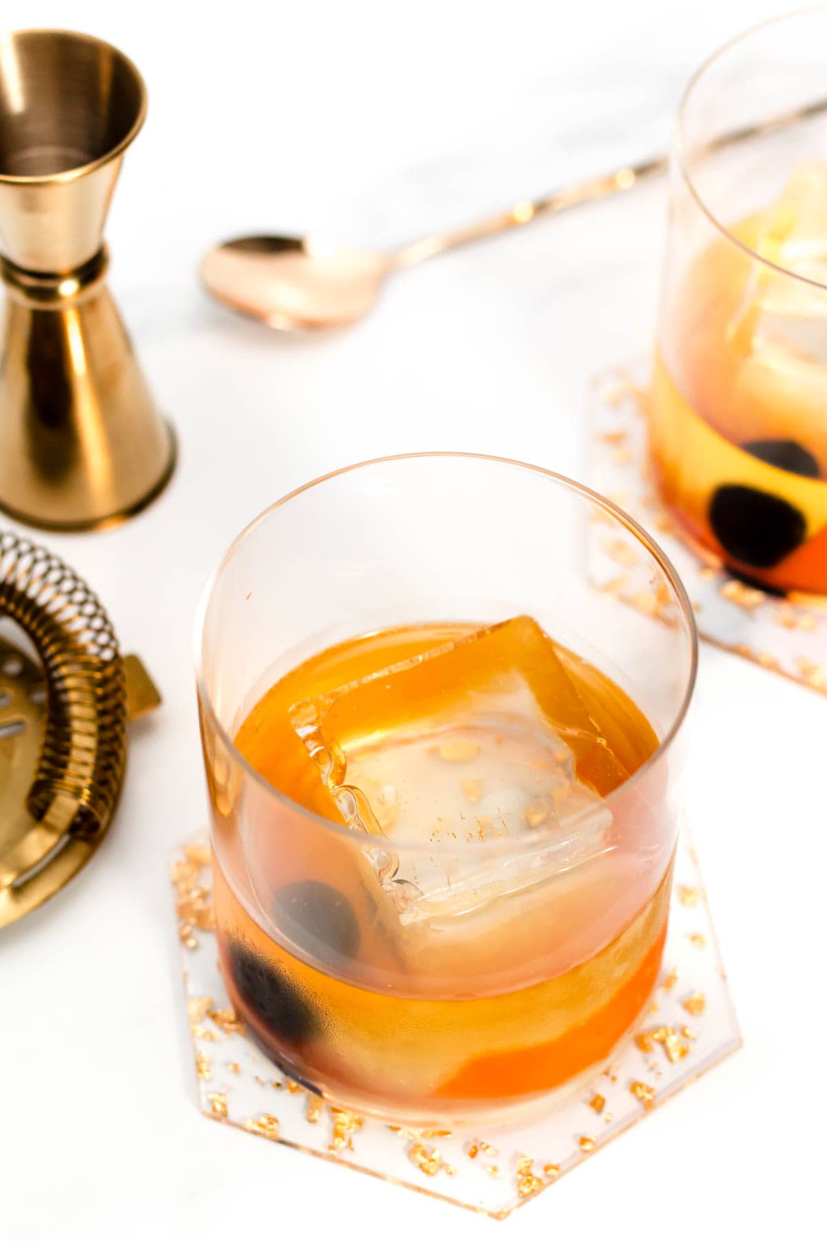 Premium Photo  Pouring whisky from a jigger into a rocks glass with a big  ice cube