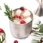 Two mugs with cranberries, pine cones and sprigs of rosemary.