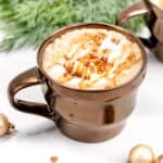 A wide shot of a caramel brulee latte in a metallic bronze mug.