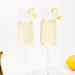 Two glasses of champagne with lemons and lemon slices.