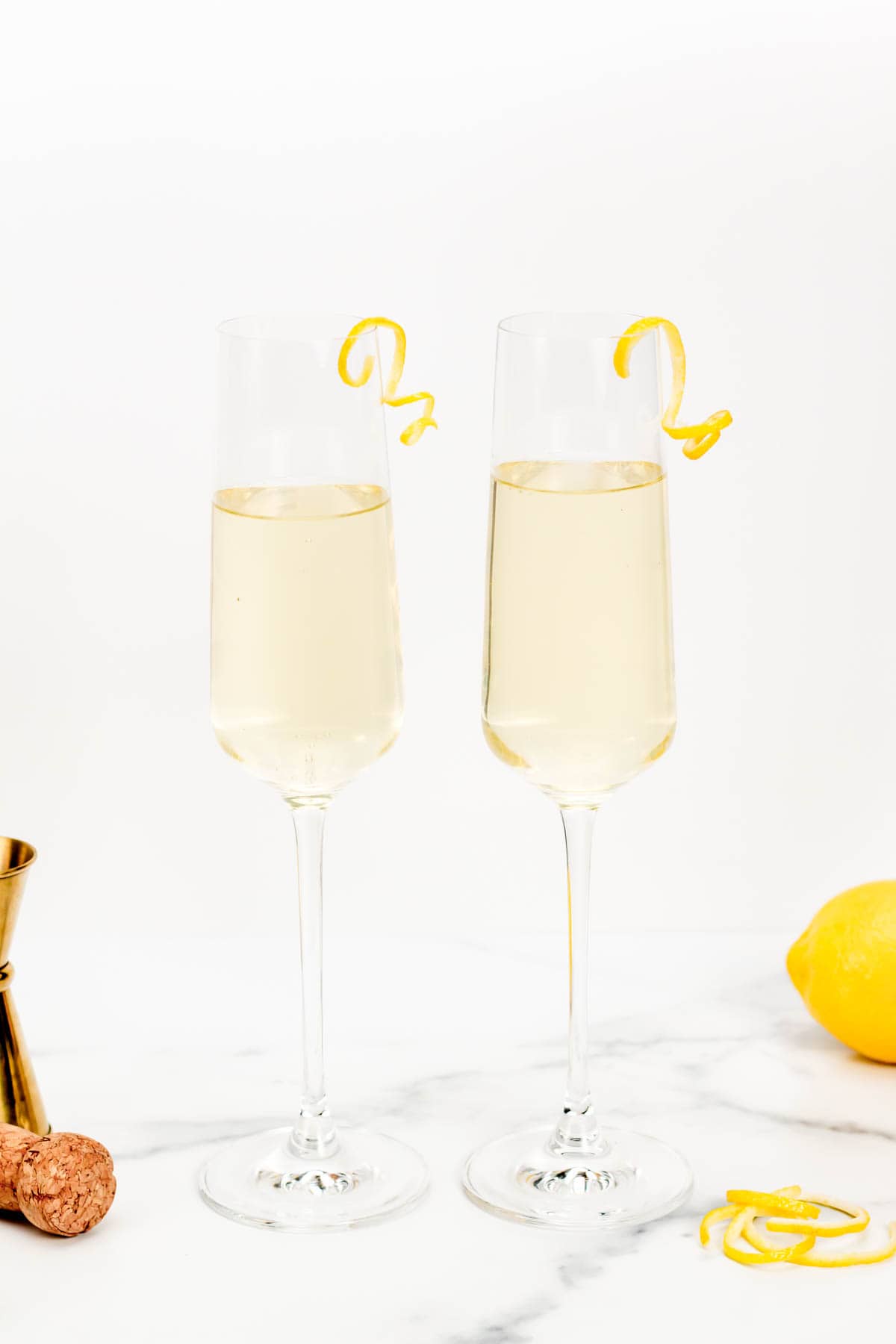 Two glasses of champagne with lemons and lemon slices.