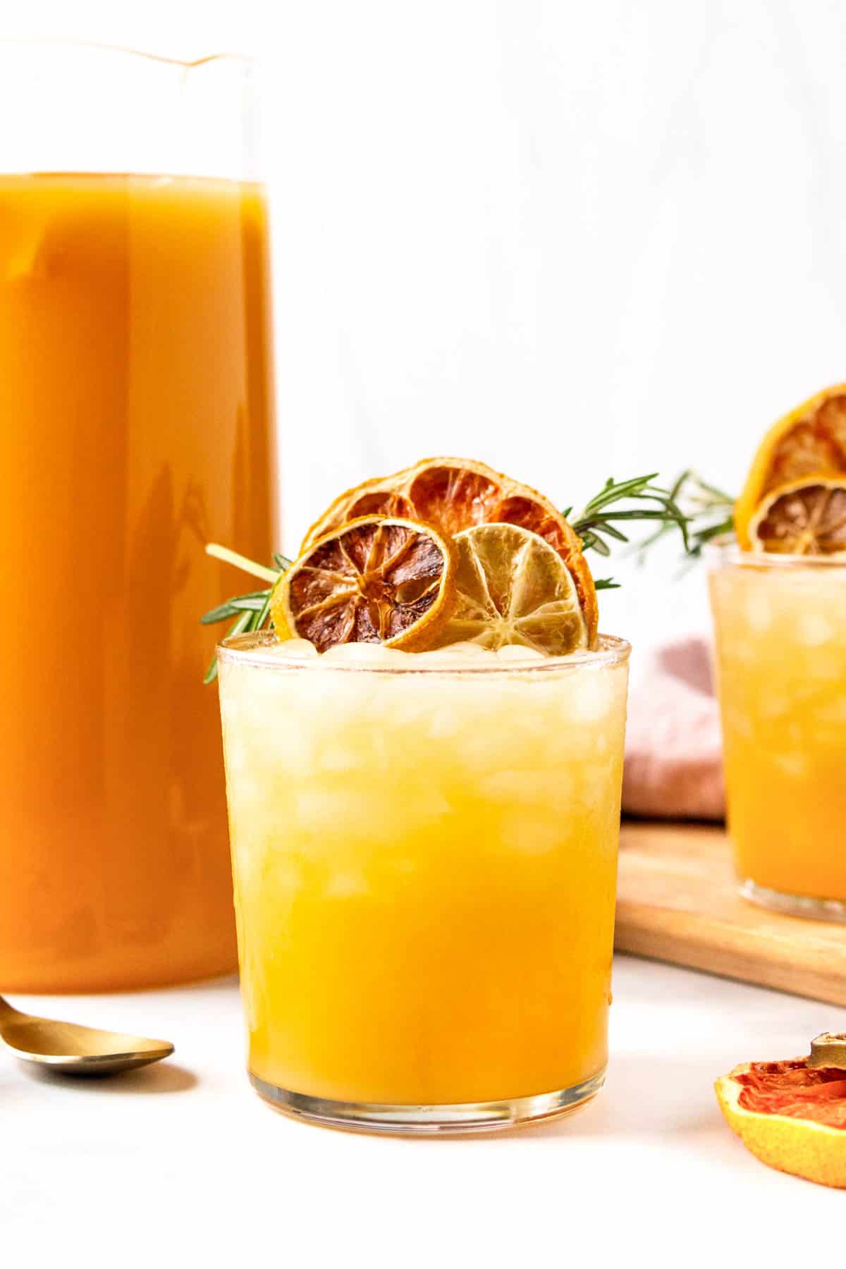 A glass of blood orange juice with a slice of orange.