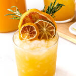 A cocktail with orange slices and rosemary sprigs.