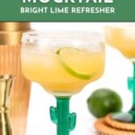 A virgin margarita mocktail with lime in a cactus glass, surrounded by bar tools and a whole lime.