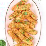 Fried mozzarella sticks on a plate with sauce and garnishes.