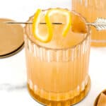 Two glasses of Penicillin Cocktail with gold garnishes, perfect for a cocktail party.