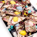 A tray of colorful easter-themed chocolate bark with sprinkles and candy eggs.